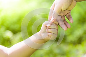 Mother is holding hands with boy boy in the wild.Hand in hand walking forward.