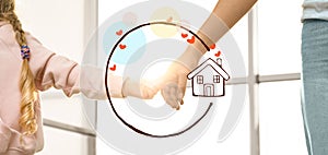 Mother holding hands with child and illustration of house indoors. Adoption concept