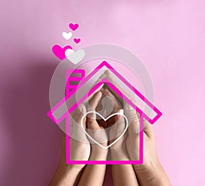 Mother holding hands with child and illustration of house on pink background. Adoption concept