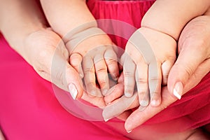 Mother holding hands of her small baby