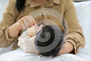 Mother holding head of her newborn baby in hand. Loving mum hand holding sleeping infant child on bed