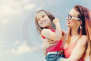 Mother holding her daughter on arm