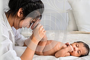 Mother holding her infant baby boy feet on hand