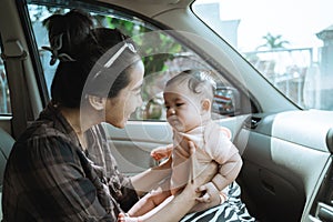 Mother holding her little baby in car