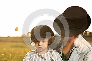 A mother holding her little daughter in her arms in the countryside