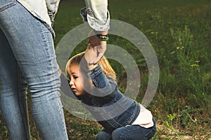 A mother holding her little daughter`s hand in the field