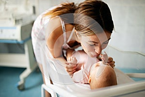 Mother holding her newborn baby child after labor in a hospital