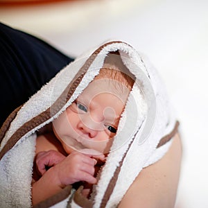 Mother holding her newborn baby daughter after birth on arms. Mum with baby girl, love. New born child cuddling in mama