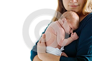 Mother holding her newborn baby daughter after birth on arms.