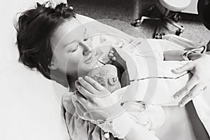 Mother holding her newborn baby after labor in a hospital.