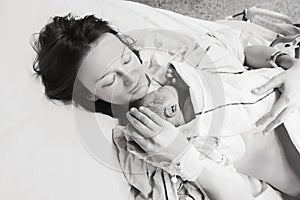 Mother holding her newborn baby after labor in a hospital.