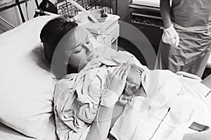 Mother holding her newborn baby after labor in a hospital.