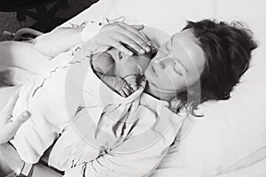 Mother holding her newborn baby after labor in a hospital.