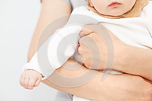 Mother holding of her newborn in hands. The baby on hands at mum. Childhood and baby care concept