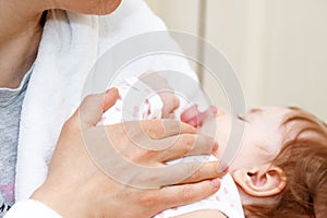 Mother holding of her newborn in hands. The baby on hands at mum. Childhood and baby care concept