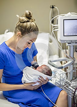 Mother holding her newborn premature baby in the hospital