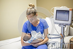 Mother holding her newborn premature baby in the hospital