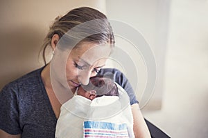 Mother holding her newborn premature baby in the hospital