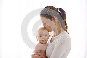Mother, holding her sick baby boy, sad baby, isolated on white