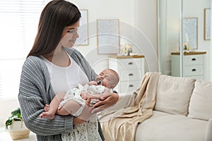 Mother holding her sleeping baby at home