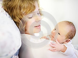 Mother holding her tiny newborn baby. Woman enjoy her first day`s as a young mom with cute infant child. Mother day