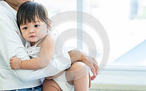 Mother holding and hugging adorable caucasian little baby daughter, playing together, the girl get sick, sleeping staying in