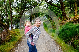 Mother holding little toddler girl in Glenveagh national park in Ireland. Smiling and laughing baby child and woman