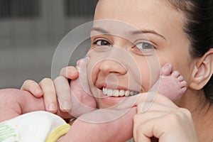 Mother  holding with love little newborns feets