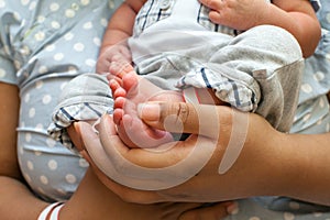 Mother holding new born babies feet