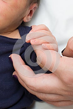 Mother holding new born babies hand