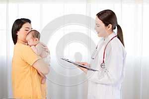 Mother holding newborn baby get sick wait pediatrician doctor taking note information of patient in paperwork checklist on