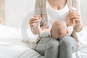 Mother holding newborn baby on lap, bonding with her child