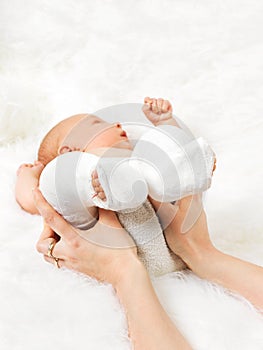 Mother Holding Newborn Babys Legs Wrapped In Banda