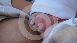 Mother Holding Newborn in Embrace and Breastfeed Her Infant, Close-up View of Baby Head, Tenderness and Care of Motherhood.