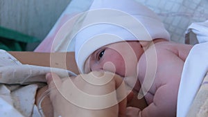 Mother Holding Newborn in Embrace and Breastfeed Her Infant, Close-up View of Baby Head, Tenderness and Care of Motherhood.