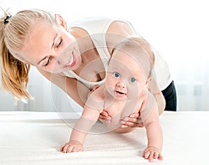 Mother holding and playing with newborn at home