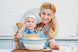 Mother holding son while he using hand