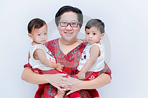 Mother holding two baby Boys. Great happiness, happy young mom with two twins baby. Portrait of young mother holding her little tw