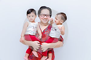 Mother holding two baby Boys. Great happiness, happy young mom with two twins baby. Portrait of young mother holding her little tw