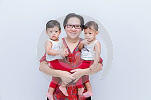 Mother holding two baby Boys. Great happiness, happy young mom with two twins baby. Portrait of young mother holding her little tw