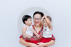 Mother holding two baby Boys. Great happiness, happy young mom with two twins baby. Portrait of young mother holding her little tw