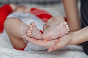 Mother holds baby feet in hands