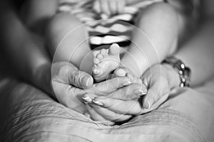 Mother holds baby feet in hands