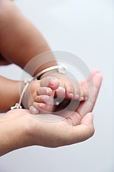 Mother holds baby feet in hands.