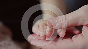mother holds the hand of a newborn. children hand. hospital takes care of happy family medicine concept. newborn baby