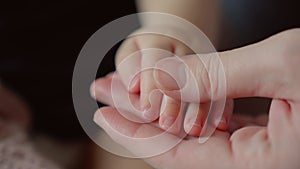 mother holds the hand of a newborn. children hand. hospital takes care of happy family medicine concept. newborn baby