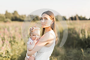 Mother holds her child in her arms, nature, calm atmosphere