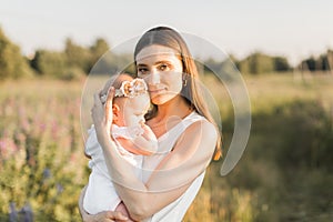 Mother holds her child in her arms, nature, calm atmosphere