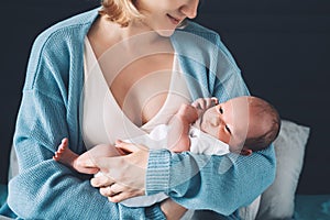 Mother holds her newborn in hands. Mom and baby together. Childbirth and motherhood concept