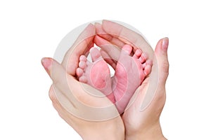 The mother holds the small child foot in her palms. Large female hand